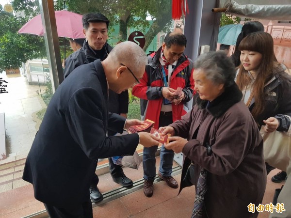 國民黨主席吳敦義今天中午前往新北市貢寮靈鷲山聖山寺發放紅包，給春節到寺廟祈福的信眾。（記者俞肇福攝）