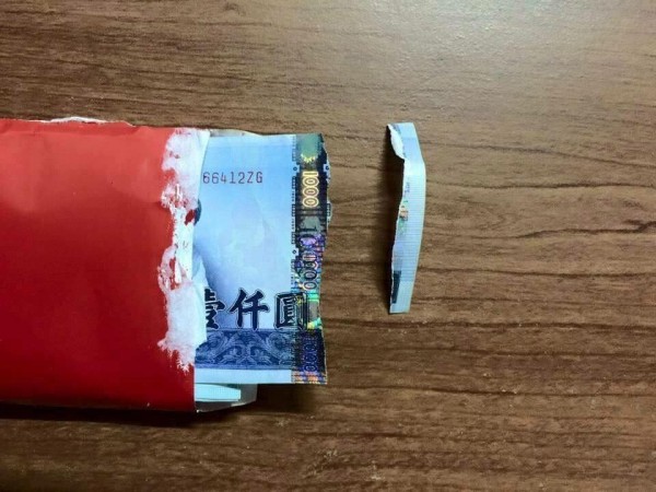 一名網友初六開工領到公司發的紅包，卻不慎撕破裡面的千元鈔票。（圖擷自臉書「爆廢公社」）