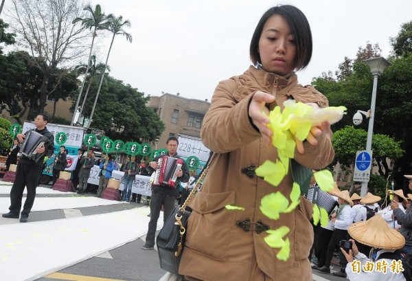 228事件71週年民團今上街遊行紀念反思，從228事件的起點天馬茶房開始遊行到行政院前，參予民眾一同灑長生花，紀念228受難者。（記者王藝菘攝）