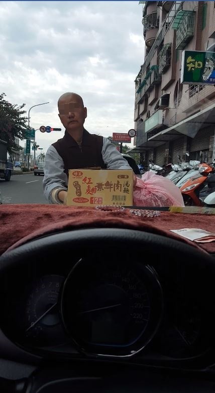 尼姑竟無視民眾坐在車上，逕自將物品搬上民眾轎車的引擎蓋。（圖擷取自爆料公社）