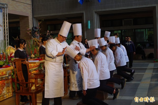 師父為學生戴上廚師帽，承諾傾囊相授，傳承餐飲技藝。（記者林國賢攝）