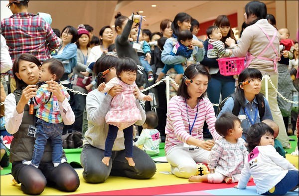 低生育率已被日本等國政府視為國家安全問題，提升職場對婦女懷孕、生育的友善度，成為重要課題。圖為2015年11月23日，日本一家親子雜誌在橫濱舉辦寶寶爬行趣味比賽。（法新社檔案照）