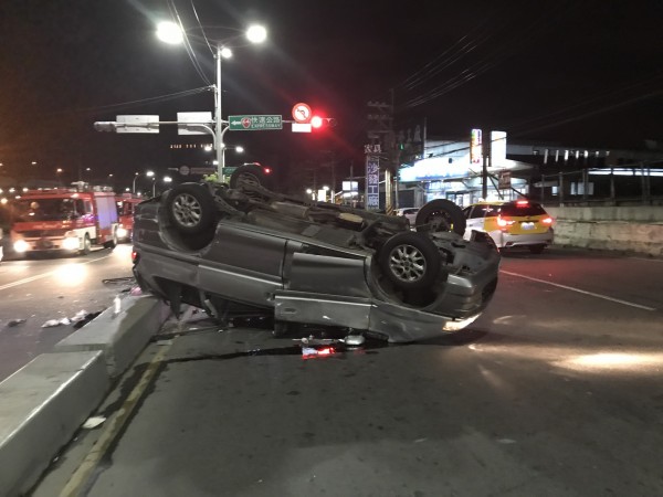 小轎車擦撞分隔島後翻覆在馬路上，所幸車上5人僅有輕傷。（記者曾健銘翻攝）