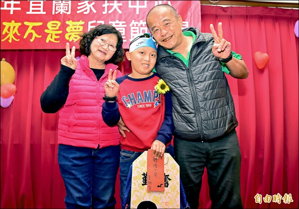 就讀小學四年級的李祐家，從小由奶奶李郭寶珠（左）及叔公李萬添（右）拉拔長大，雖然雙腿肌肉萎縮，但他靠著堅持，在游泳運動找回自信。（記者張議晨攝）