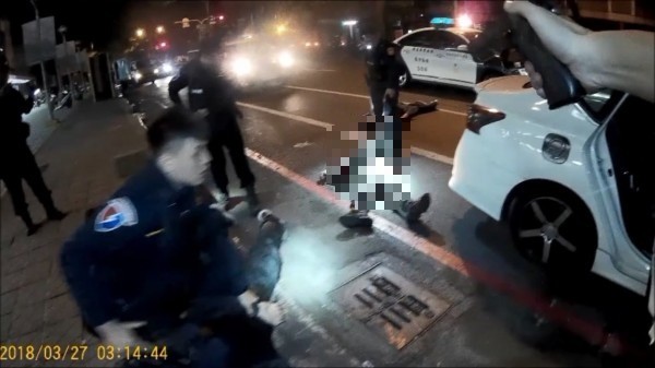 高雄街頭警匪槍戰，歹徒拔槍警方駁火影片曝光，警方拉出中彈的陳祈安急救。（記者黃良傑翻攝）