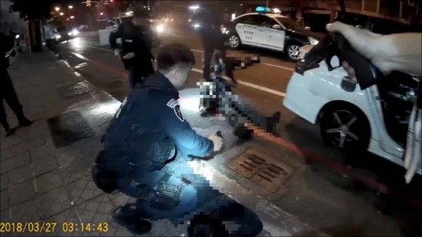 高雄街頭今晨發生警匪槍戰，警方拉出中彈的陳祈安急救。（記者黃良傑翻攝）