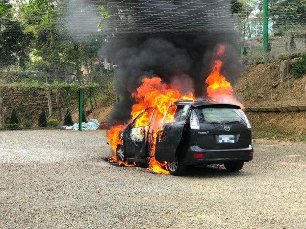 黑色二手車在蘇維拉莊園停車場空地竄出大火。（記者鄭名翔翻攝）