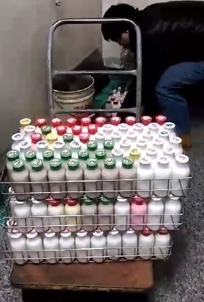 台南檢調衛專案人員查扣小叮噹鮮羊乳地下工廠內已裝瓶的疑似冒牌羊乳。（記者王俊忠翻攝）