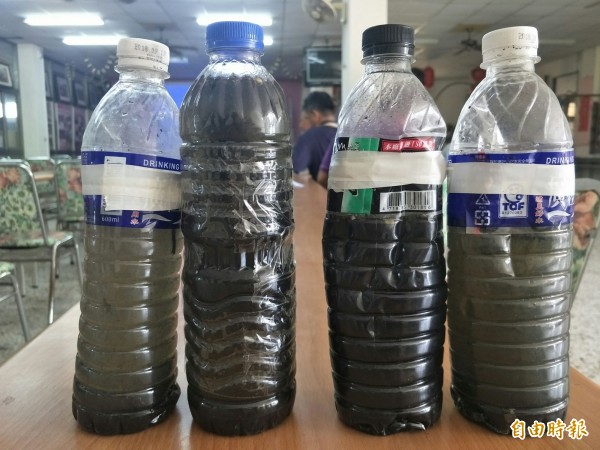漁民自行採樣發現,左邊寶特瓶顯示,油質物數日後數會自行沉澱水下。(記者陳冠備攝) 漁民自行採樣發現,左邊寶特瓶顯示,油質物數日後數會自行沉澱水下。(記者陳冠備攝)