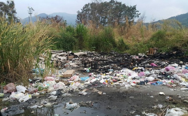 水里鄉市區周邊的堤防空地，遭人長期亂丟垃圾焚燒，地方忍無可忍向環保局檢舉。（記者劉濱銓翻攝）