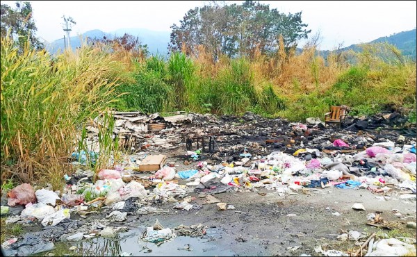 水里鄉市區周邊的堤防空地，遭人長期亂丟垃圾焚燒，地方忍無可忍向環保局檢舉。（記者劉濱銓翻攝）