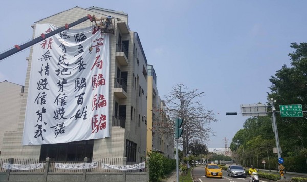 竹科服務區配租安置戶籌建委員會今早在服務區房舍立面吊掛巨型白布條，表達抗議。（圖由現場民眾提供）