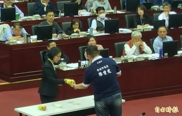 台北市議員陳重文拿洋蔥給北農總經理吳音寧看，問題連發。（記者楊心慧攝）