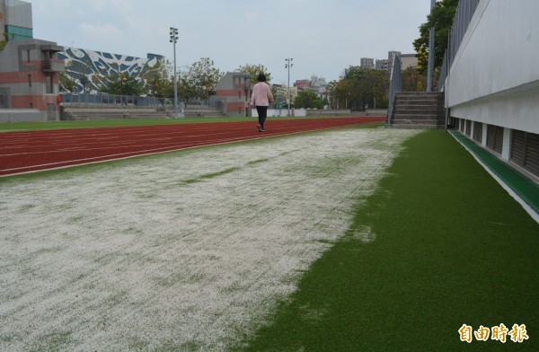 大里運動公園新啟用的田徑場，人工草皮上布滿石英砂，民眾質疑施工草率。（記者陳建志攝）