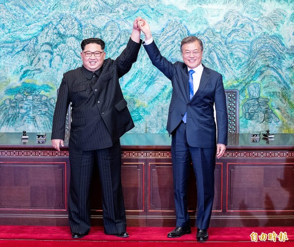 
North Korean leader Kim Jong-un, left, and South Korean President Moon Jae-in yesterday raise their joined hands at the truce village of Panmunjom inside the Demilitarized Zone separating the two countries.
Photo: Reuters / Korea Summit Press Pool