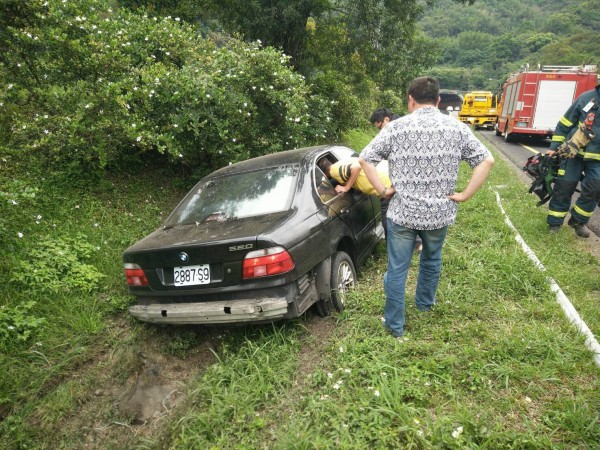 高速公路爆胎撞邊坡，消防人員到場後破壞車身救出駕駛。（記者邱俊福翻攝）