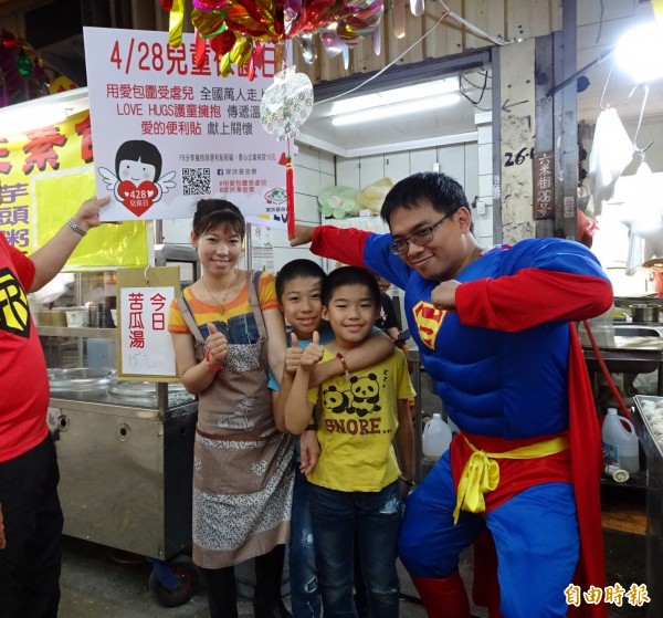 社工化身超人上市場宣傳「保護兒童」，獲攤商大人小孩響應。（記者蔡淑媛攝）
