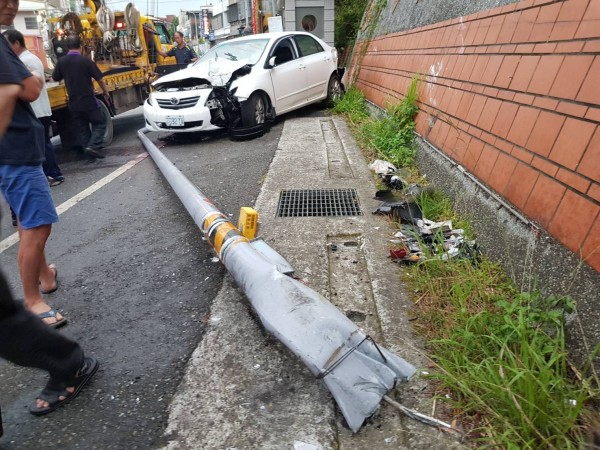 小客車將路旁燈桿連根撞倒。（記者彭健禮翻攝）