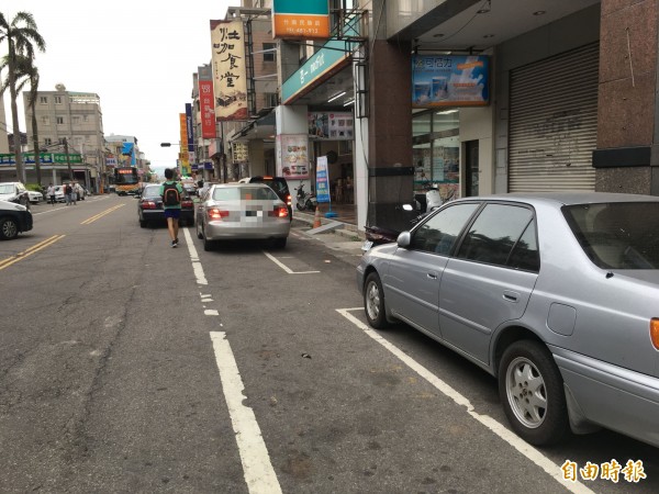 竹南鎮市區停車位一位難求，常有車主違規並排停車，導致人車爭道交通問題。（記者鄭名翔攝）