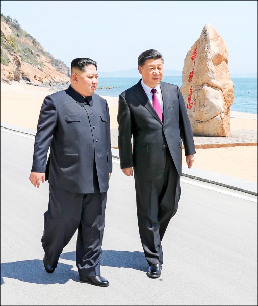 金正恩（左）七日至八日前往中國大連，與習近平（右）並肩漫步於大連海灘。（美聯社）
