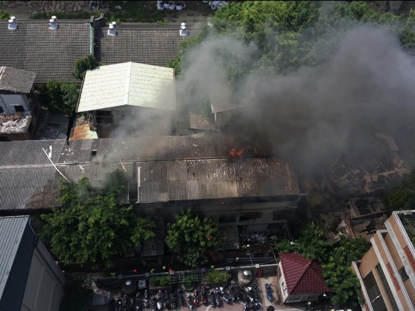 台中市復興路上的台鐵舊宿舍又傳祝融，濃煙直竄天際；從空中鳥瞰，可見火勢威脅其他緊鄰民宅。（記者許國楨翻攝）