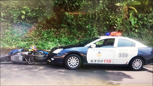 騎士因滿地的西瓜汁影響打滑摔車，撞到路旁警車。（記者徐聖倫翻攝）