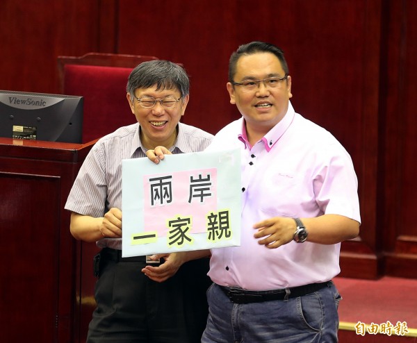 台北市長柯文哲１４日前往市議會，進行專案報告，議員陳重文將「兩岸一家親」牌子送給柯文哲。（記者方賓照攝）