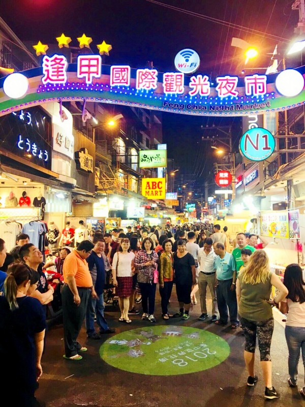 台中花博吉祥物投影現身逢甲夜市，引起民眾圍觀。（台中市政府經發局提供）