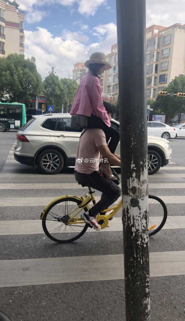 男子騎單車肩上還跨坐著一名女子，這種雙載法嚇壞路人。（圖翻攝自微博）