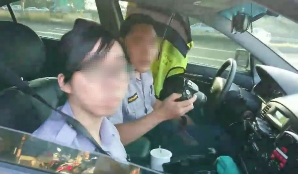 2名員警將巡邏車開至道路視線死角處，以地物作掩護對道路駕駛人進行違規取締，有機車騎士對此向2名員警怒嗆違反警政署標準作業流程。（圖擷取自爆料公社）