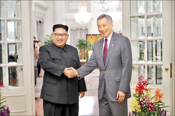 北韓領導人金正恩（左）十日抵達新加坡，在星國總統府與星國總理李顯龍（右）會面。（歐新社）