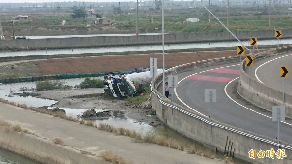 載運液態瓦斯的槽車，翻落台南61線台南北門交流道外的鹽田，車頭壓扁，司機輕傷。（記者楊金城攝）