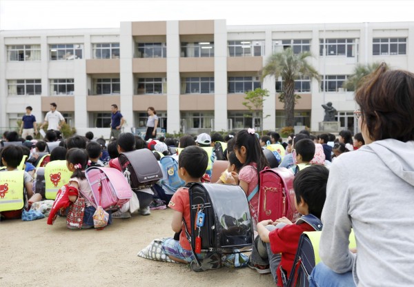 強震導致一名9歲女童及80歲男子遭牆壁重壓，送醫後不治。圖為日本國小學童在校園避難。（路透）