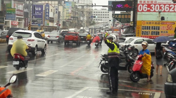 大橋派出所員警今上午在雨中指揮交通，讓永康中華路交通得以順暢。（記者萬于甄翻攝）