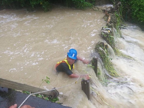 高市截流溝遇豪雨湍急如瀑布，水利局工程人員跳人清淤撼動民心，興宗里長拍下感人的照片，感謝市府團隊守護家園。（記者黃良傑翻攝）