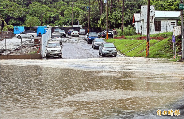 高雄市昨下大雨，左營軍校路附近一帶積水不退。（記者張忠義攝）