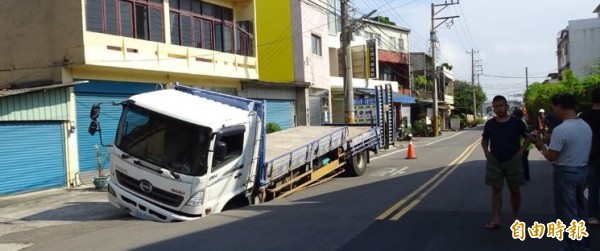 大貨車被馬路吃掉了？ 疑是管線漏水掏空肇禍。（記者洪美秀攝）