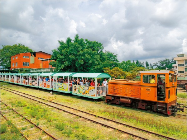 復古五分車緩緩從中興車站駛出，沿途可見多條平行鐵軌及甘蔗車廂陳列。（記者王姝琇／攝影）