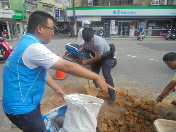 員警、民眾合力剷除路面土石。（記者許倬勛翻攝）