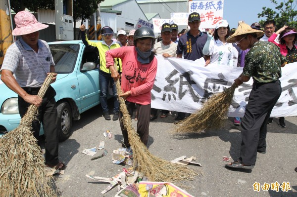 民眾手持掃把演出行動劇，並怒喊：「東泰滾出去」。（記者陳冠備攝）