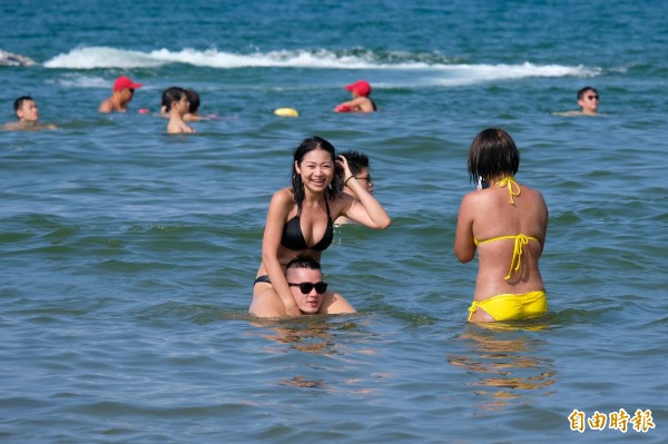 福隆海水浴場戲水區滿滿人潮，大夥兒泡在水裡享受清涼。（記者林欣漢攝）