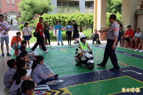 「小小超級戰警」體驗營在葫蘆墩國小舉行，小朋友透過騎警車學習交通安全規則。（記者歐素美攝）