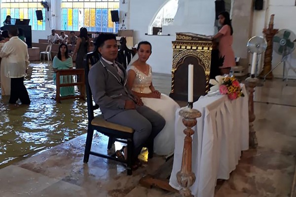 菲國一對新人週六（11日）在淹水中的教堂舉行婚禮，還被網友譽為「年度最佳婚禮」（wedding of year）。（法新社）