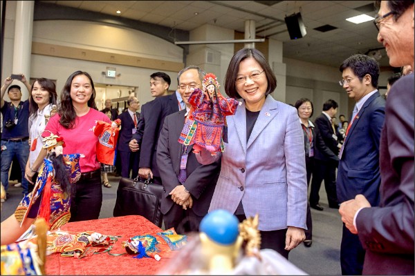 蔡英文總統「同慶之旅」首站抵達美國洛杉磯，視察僑教中心時與正在學習布袋戲文化的青少年一同操偶。（圖取自總統府網站）