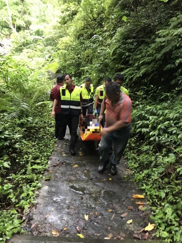 消防人員合力扛著方姓研究生下山急救。（記者江志雄翻攝）