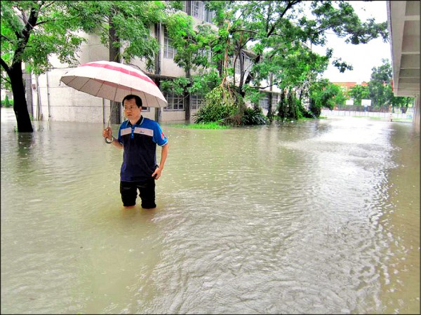 新園國中一度泡在水裡，校長陳冠良巡視校園。（新園國中提供）