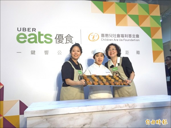 喜憨兒基金會成為UberEats首個公益合作夥伴，圖為UberEats台灣區總經理李佳穎（左）、喜憨兒基金會董事長蕭淑珍（右）與憨兒共同製作月餅。（記者陳宜加攝）