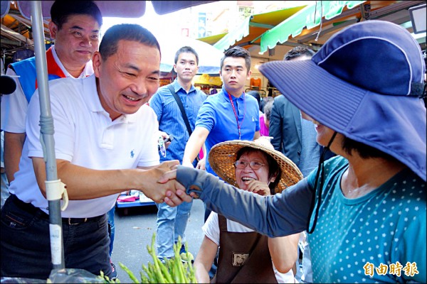 國民黨新北市長參選人侯友宜昨到新莊宏泰市場掃街拜票，與攤販一一握手致意。（記者葉冠妤攝）