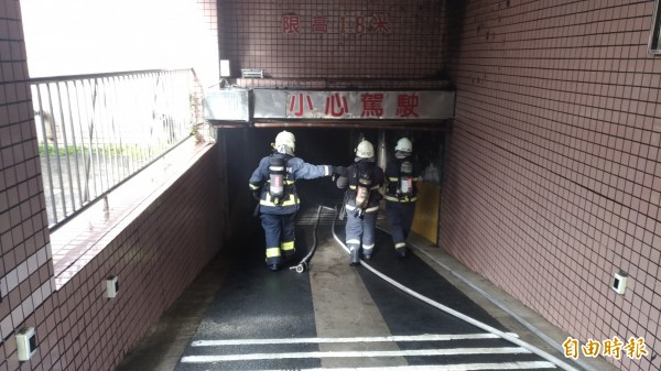 宜蘭市延平路一棟住宅大樓今晨地下室冒出濃煙，消防人員前往灌救。（記者張議晨攝）