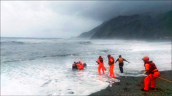 女教師在宜蘭東澳粉鳥林落海，搜救人員在身上綁繩，冒著巨浪以接力方式將陳女遺體拉上岸。（記者張議晨翻攝）